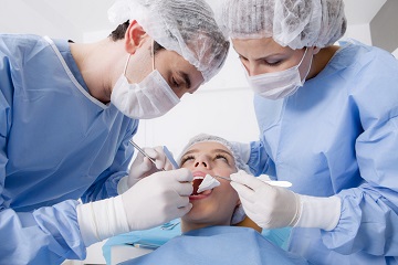 dentysta z asystentką podczas pracy w gabinecie