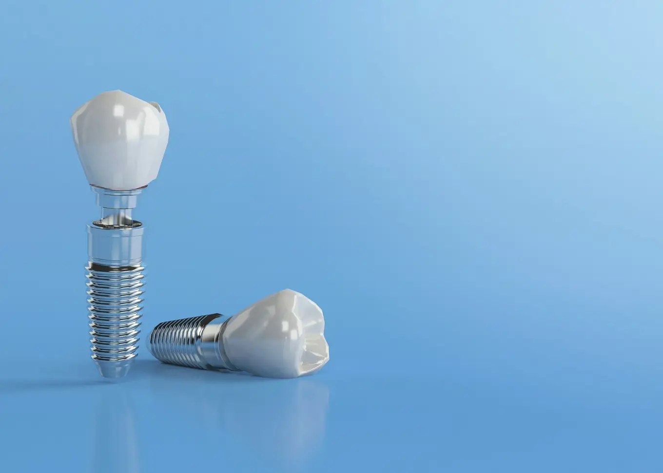 dwa implanty zębowe na niebieskim tle