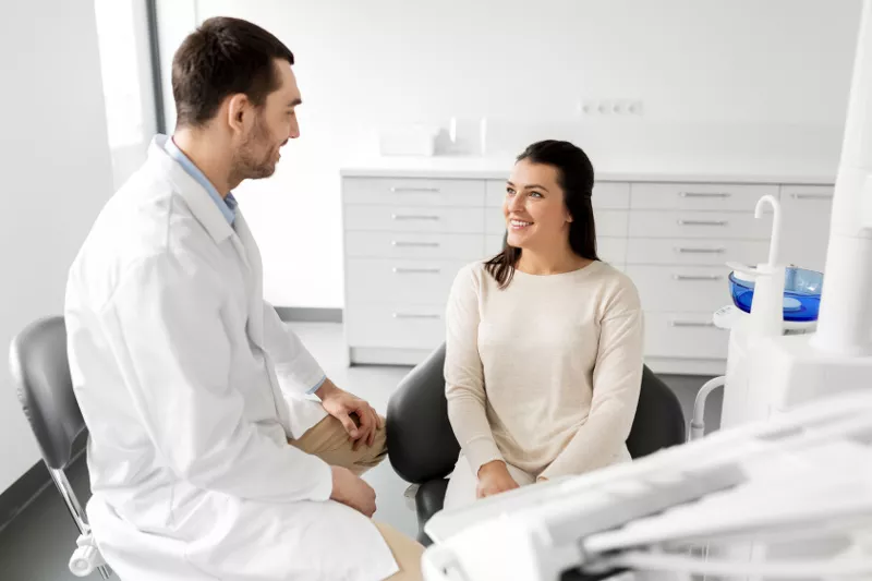 Dentysta przeprowadza rozmowę z kobietą