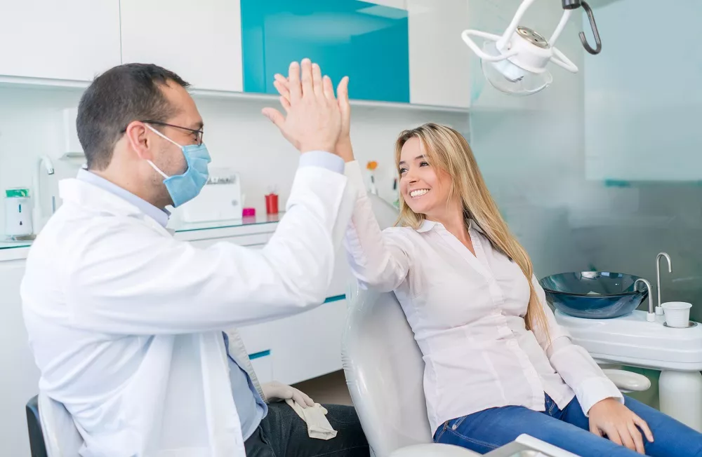 Dentysta przybija piątkę z pacjentką